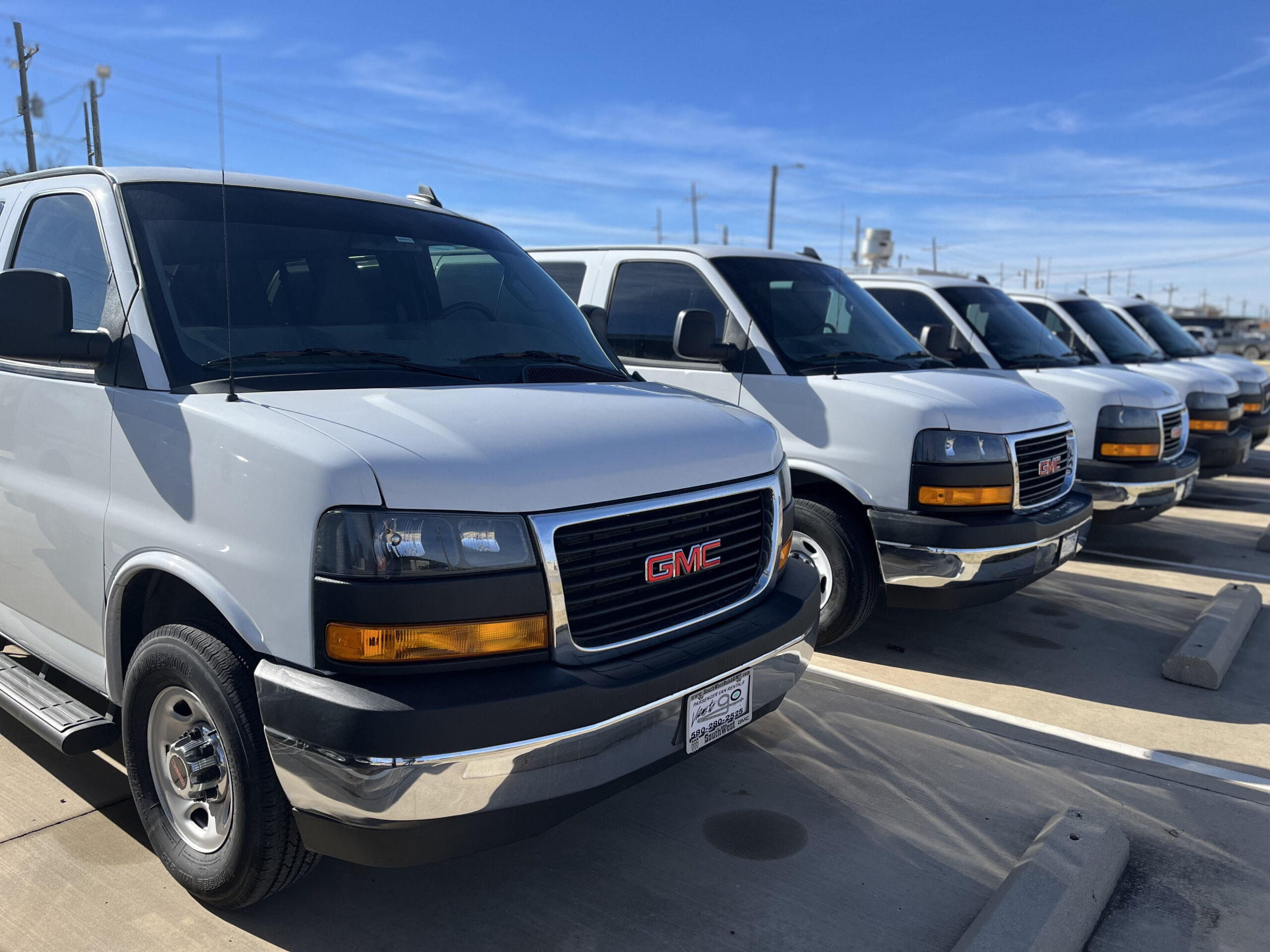 Full size white vans parked on a parking lot